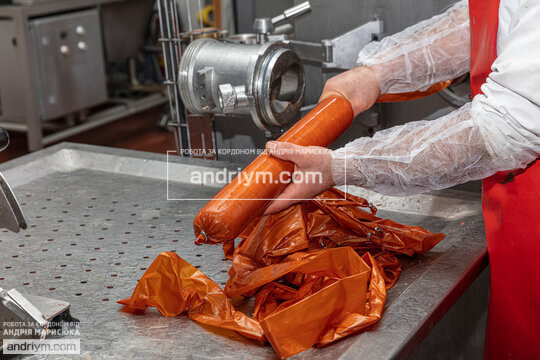 Worker at final stages of sausage production